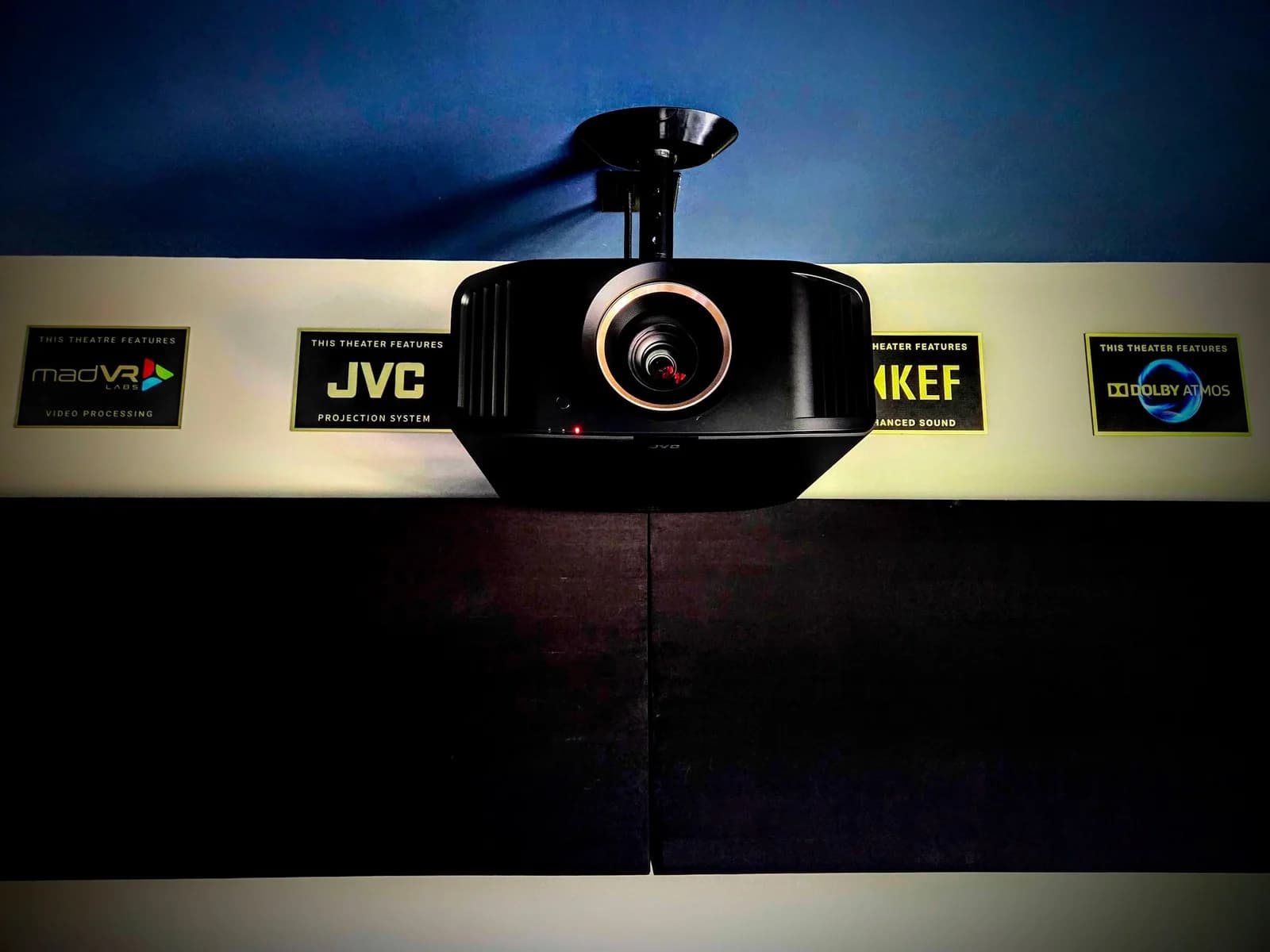 Ceiling-mounted JVC projector with madVR, KEF, and Dolby Atmos brand plaques