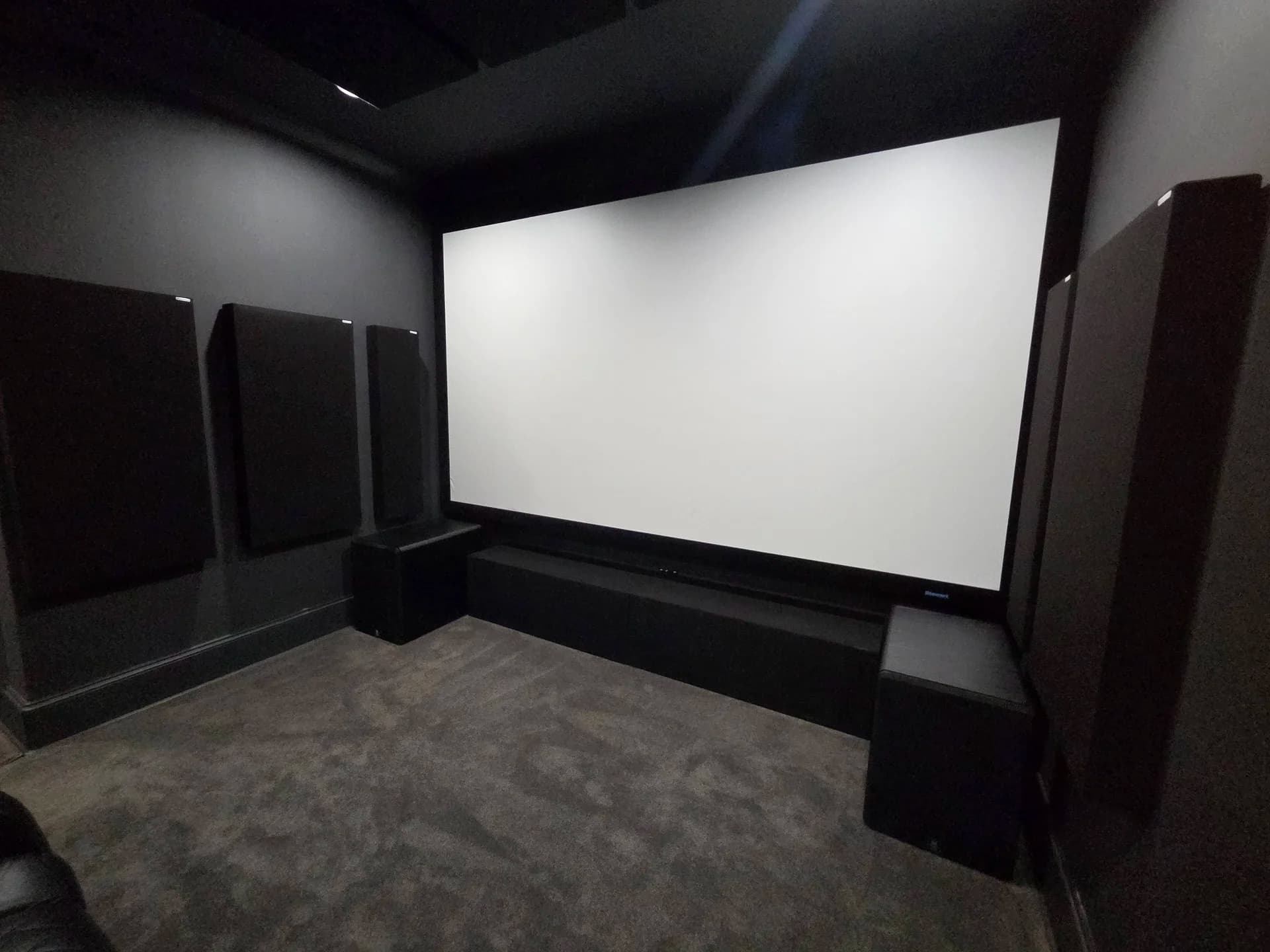 The completed screen wall. The owner's front speakers sit behind the acoustically transparent surface, with his subwoofers flanking the stage