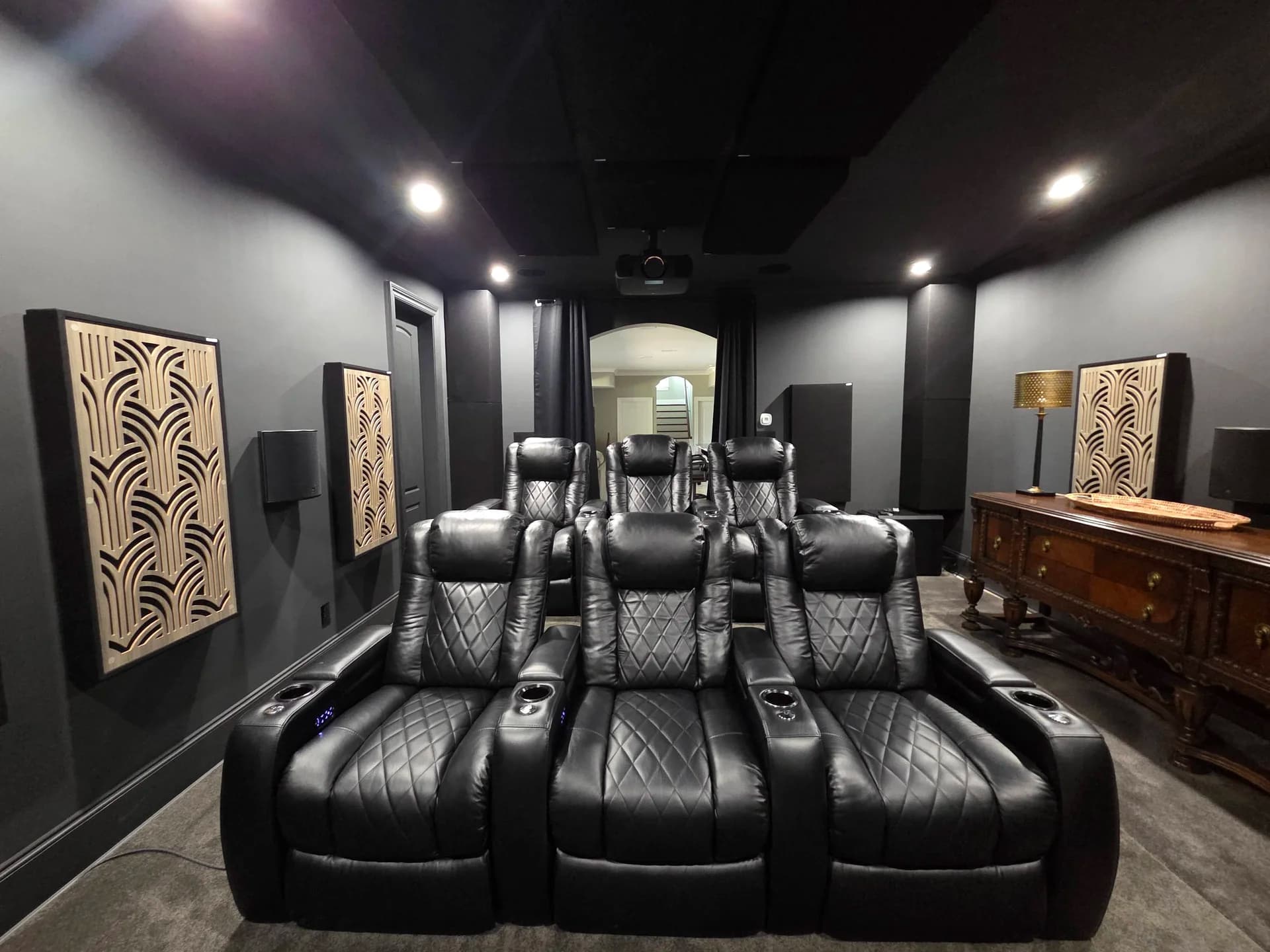 Looking back from the screen — acoustic treatment along both side walls, with the owner's seating and riser